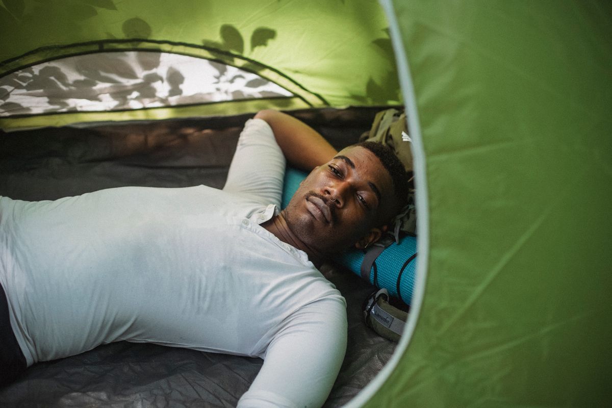 Wanderer liegt im Zelt und blickt nach draußen